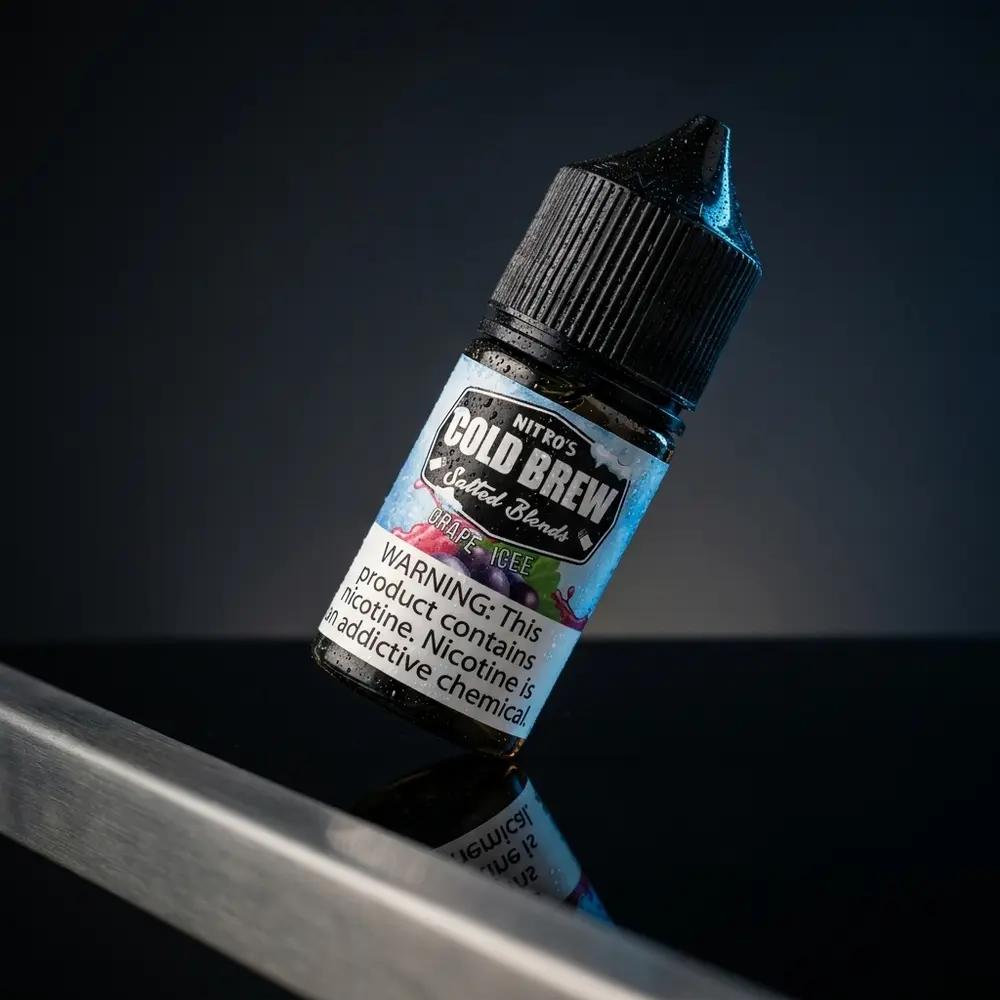 Frasco do liquido Nitros Cold Brew Salt Grape Ice inclinado sobre base preta brilhante com reflexos roxos - Vapor Gringo