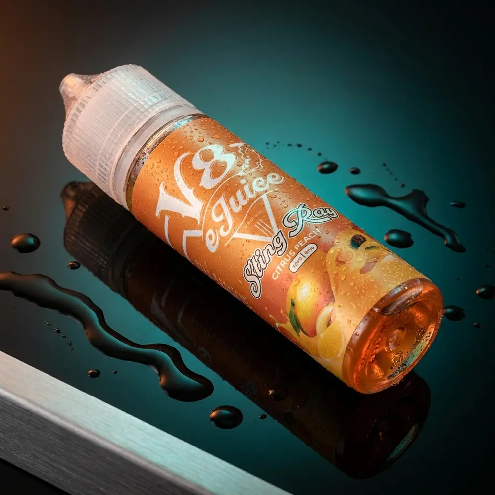 Frasco Líquido V8 E-Juice Citrus Peach 60ml sobre acrílico preto com gotas e luzes laranja-peach - Vapor Gringo