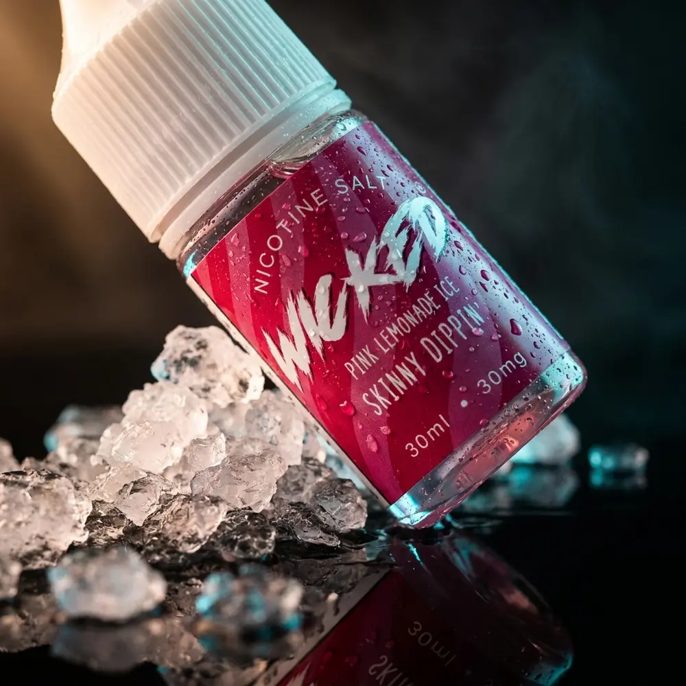 Garrafa do Liquido Wicked Salt Pink Lemonade Ice sobre acrilico brilhante com condensacao e reflexos rosa e ciano - Vapor Gringo