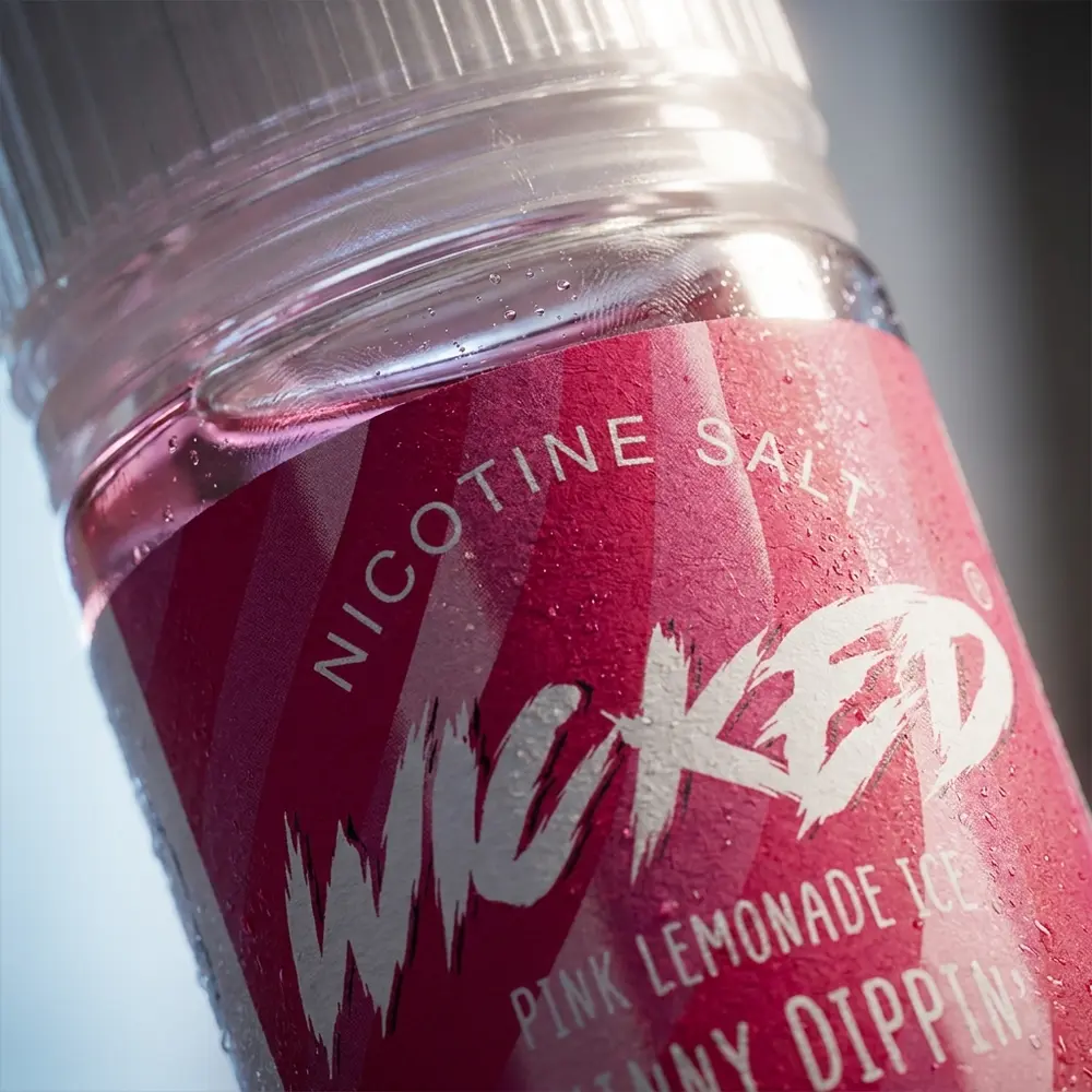 Detalhe macro do rotulo e bico do Liquido Wicked Salt Pink Lemonade Ice com gotas de agua e textura do vidro - Vapor Gringo