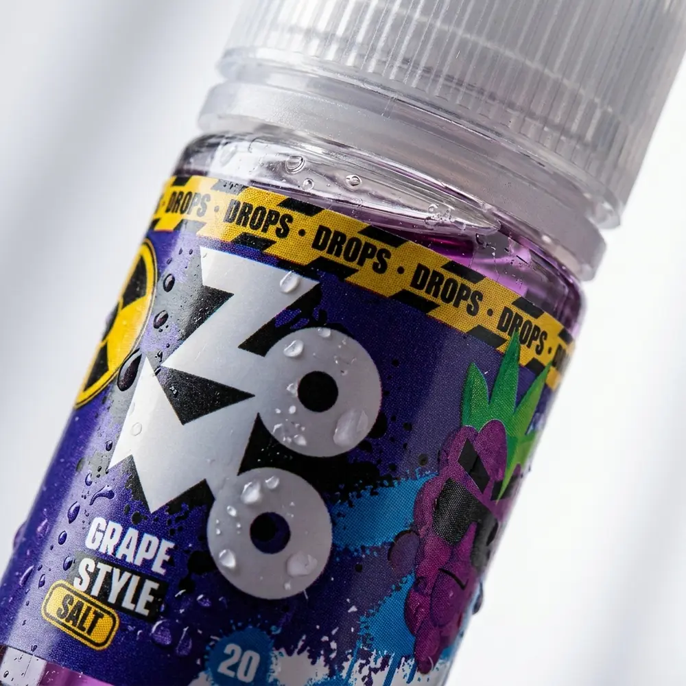 Close macro do rótulo do Líquido Zomo Grape Style Drops com gotas de condensação e textura do vidro - Vapor Gringo