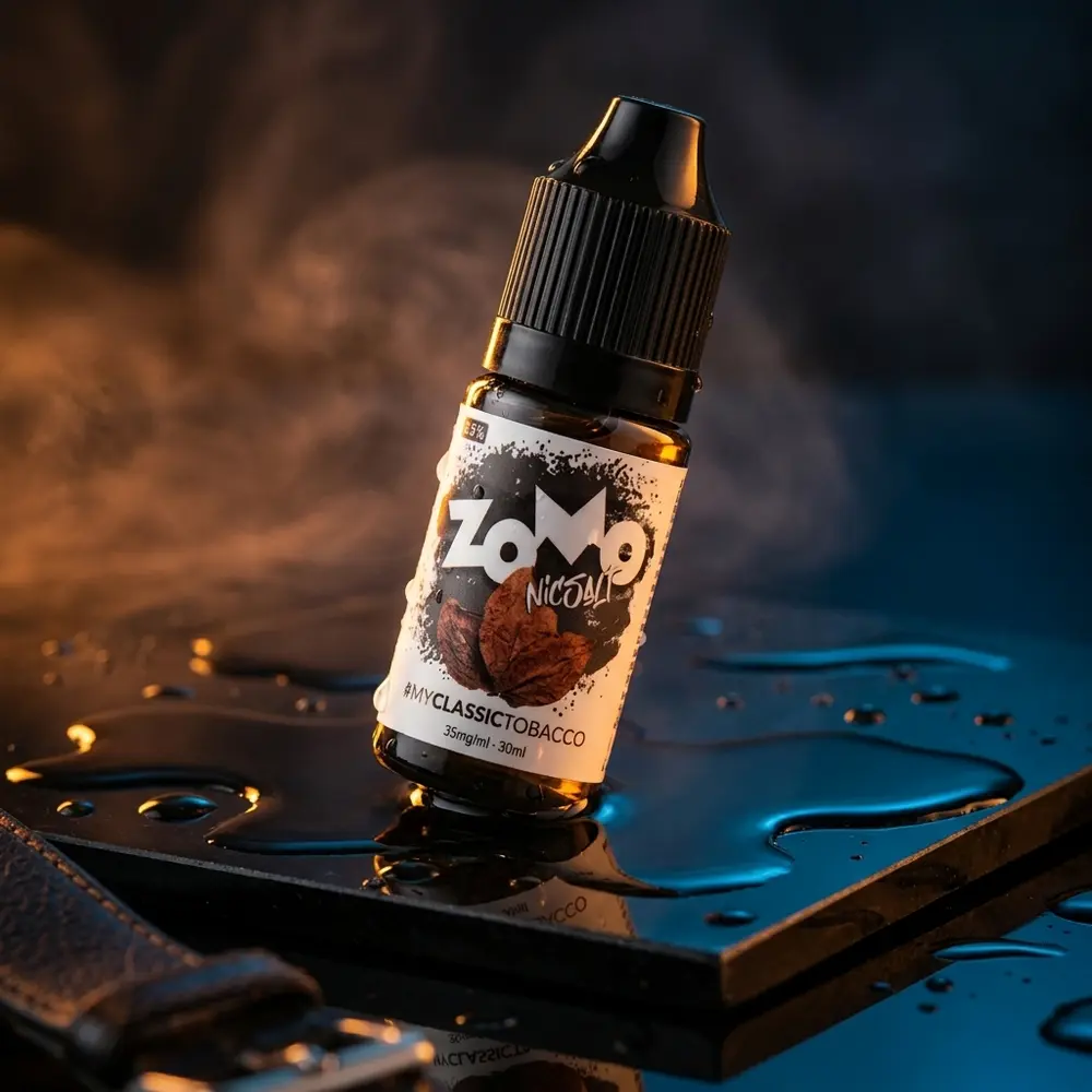 Frasco Líquido Zomo Salt Classic Tobacco posado inclinado sobre base preta molhada, luz âmbar quente, reflexos e névoa - Vapor Gringo