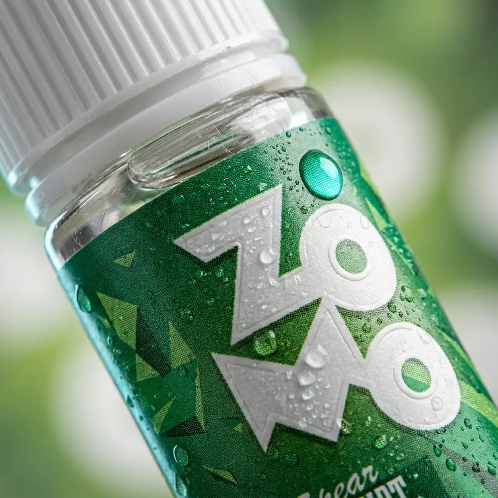 Close-up do rótulo e bico da garrafa Liquido Zomo Salt Spear Mint com gotas, textura e reflexos - Vapor Gringo