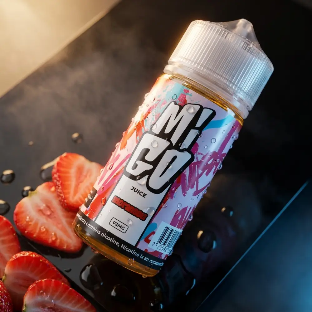 Frasco do liquido Migo Morangou 100ml sobre base preta brilhante com morangos fatiados e reflexos de estúdio - Vapor Gringo