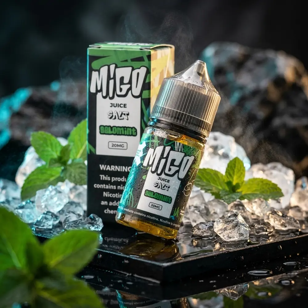 Garrafa Líquido Migo Salt Gelomint sobre base preta molhada com gelo e folhas de menta, luz ciano e dourada - Vapor Gringo