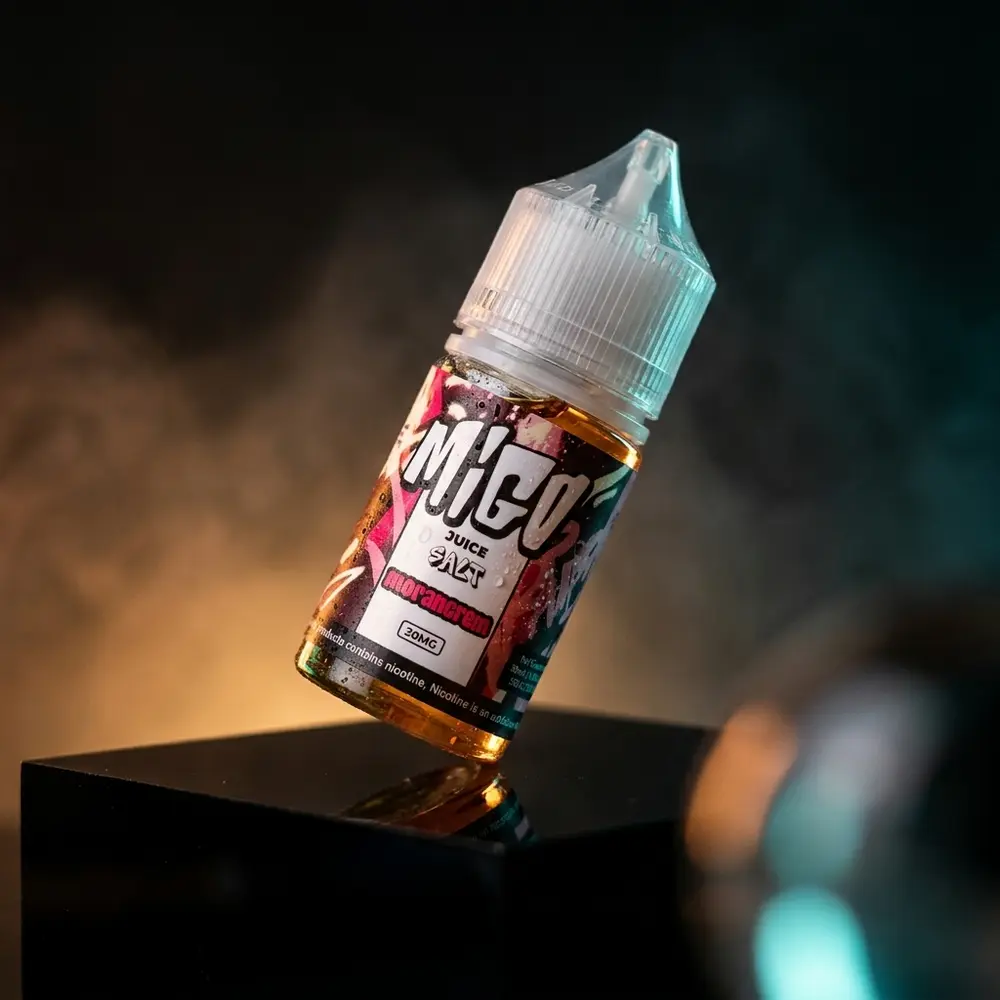 Frasco Líquido Migo Salt Morancrem sobre acrílico preto, garrafa inclinada com iluminação âmbar e teal - Vapor Gringo