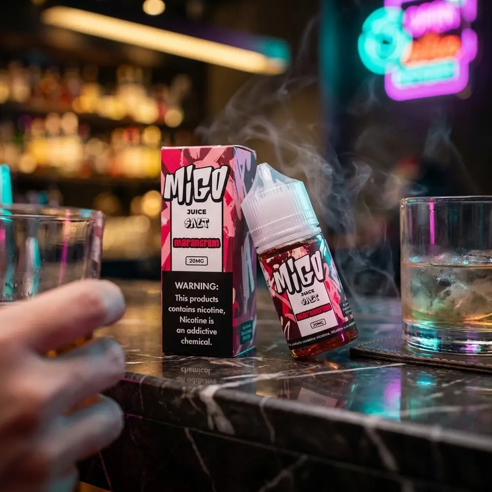 Líquido Migo Salt Morancrem sobre bancada de bar em cenário noturno com neon desfocado e copo ao lado - Vapor Gringo