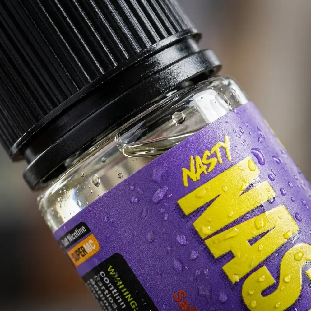 Close-up do rótulo e bico do Líquido Nasty Juice Salt Fruit Fusion 30ml com gotas de condensação e reflexos metálicos - Vapor Gringo