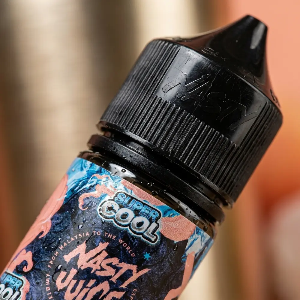 Close-up do rótulo e bocal do Líquido Nasty Juice Salt Peach Ice com gotas e textura detalhada - Vapor Gringo