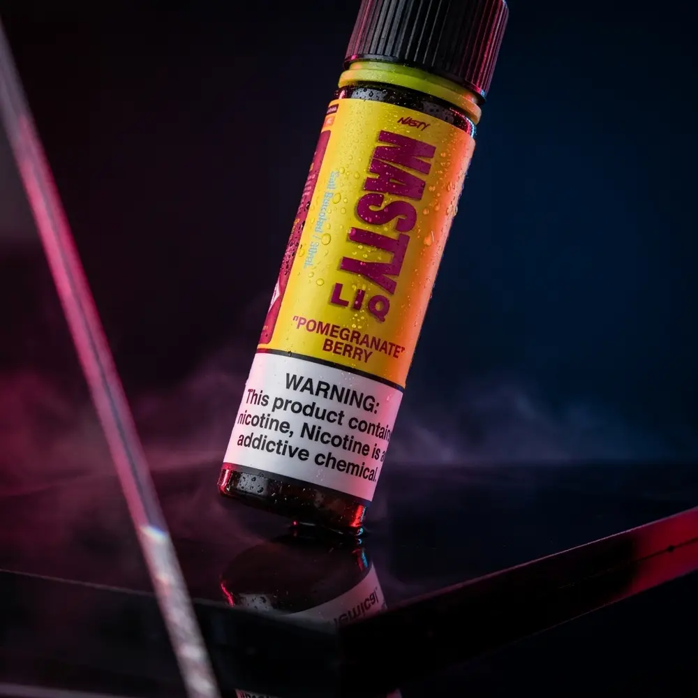 Garrafa 30ml Nasty Juice Salt Pomegranate Berry sobre acrilico preto com iluminacao magenta e gotas de condensacao - Vapor Gringo
