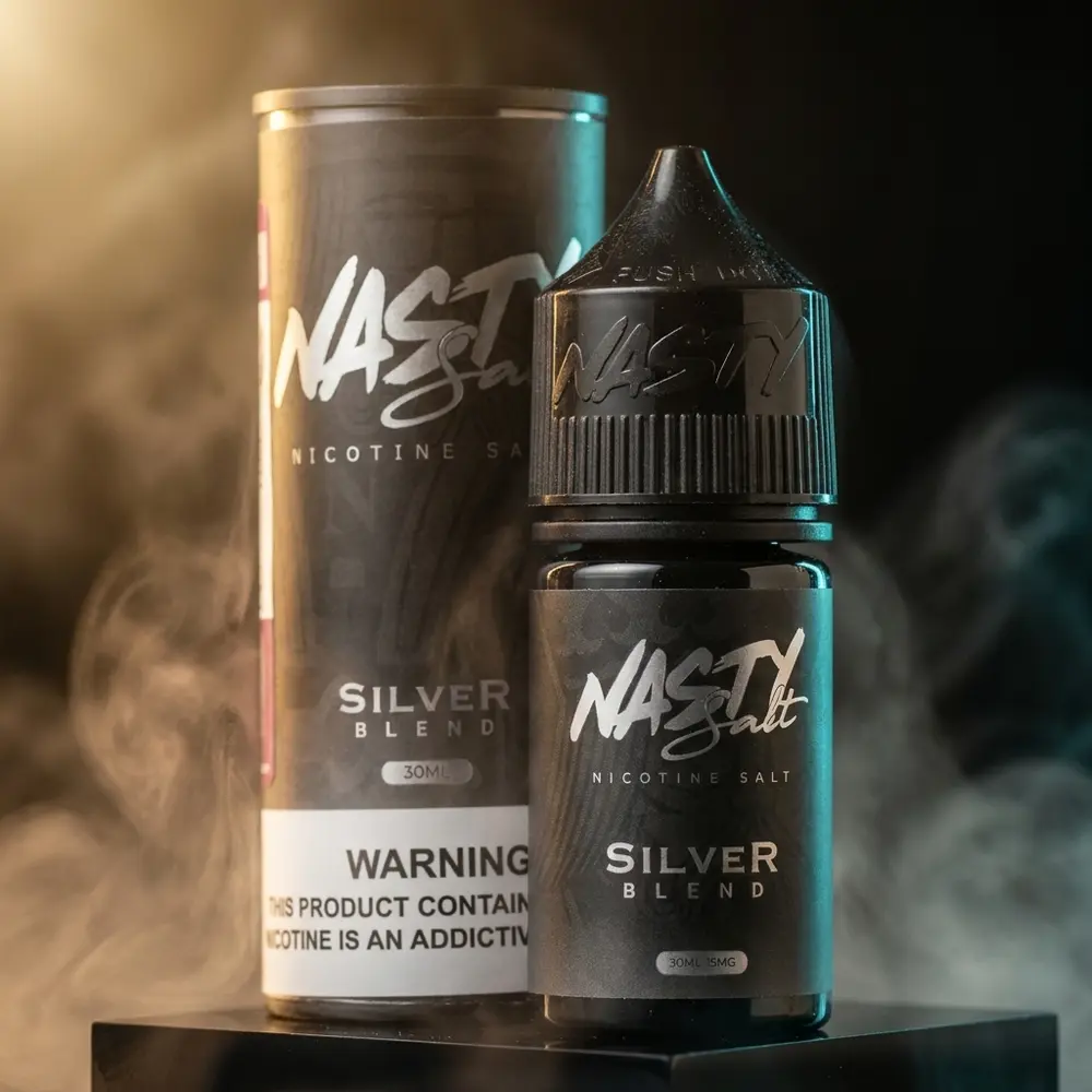 Frasco Nasty Juice Salt Silver Blend em close sobre base acrílica preta com luzes quentes e reflexos metálicos - Vapor Gringo