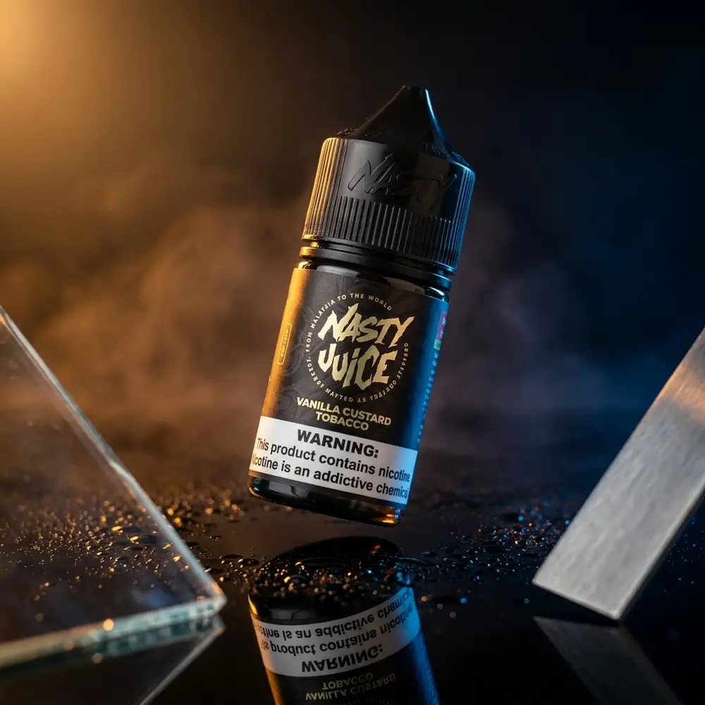Garrafa do Líquido Nasty Juice Salt Vanilla Custard Tobacco sobre acrílico preto com luz âmbar e reflexos - Vapor Gringo