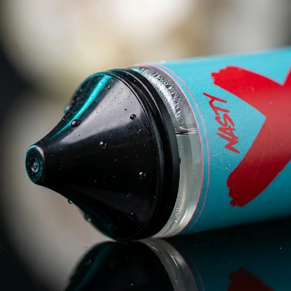 Macro do rotulo e bico do frasco Nasty Juice Salt Watermelon Bubblegum 30ml com gotas de condensacao e reflexos metalizados - Vapor Gringo