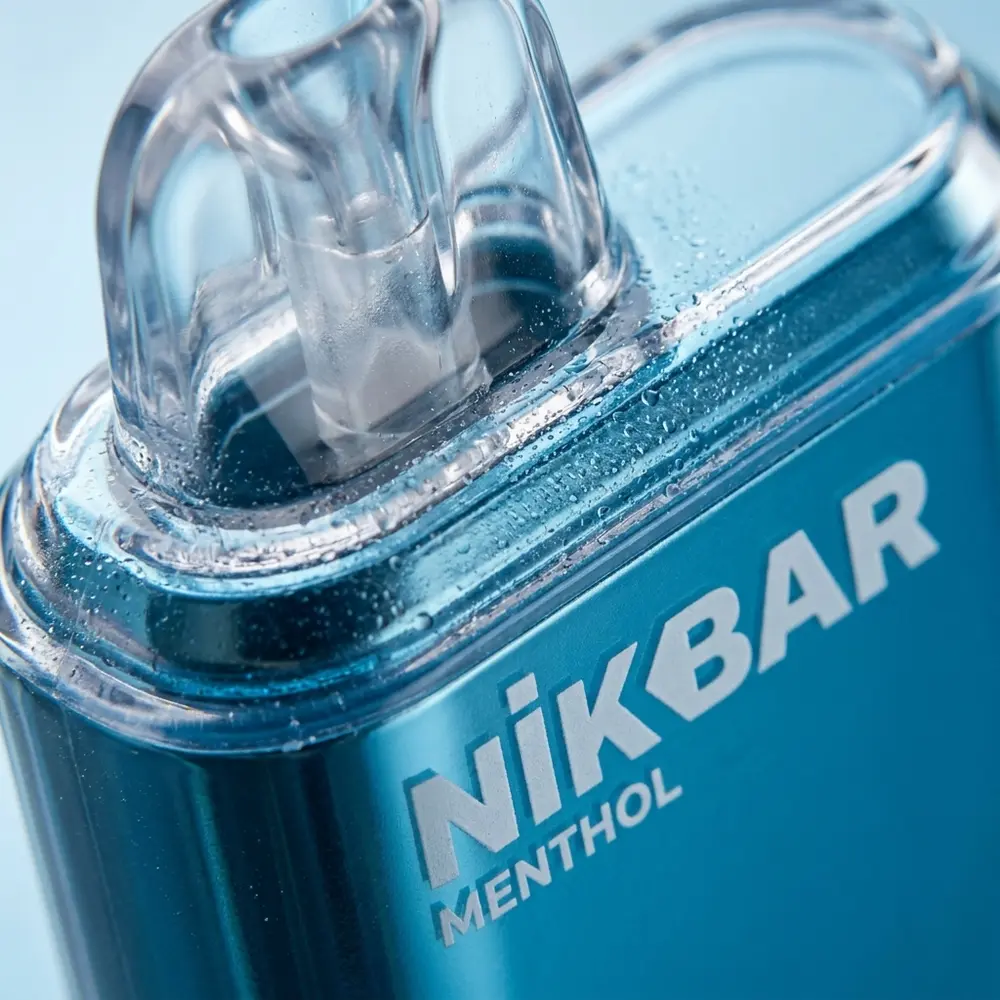 Close-up do NikBar 15.000 puffs menthol na boquilha, detalhe de textura, condensacao e reflexos - Vapor Gringo