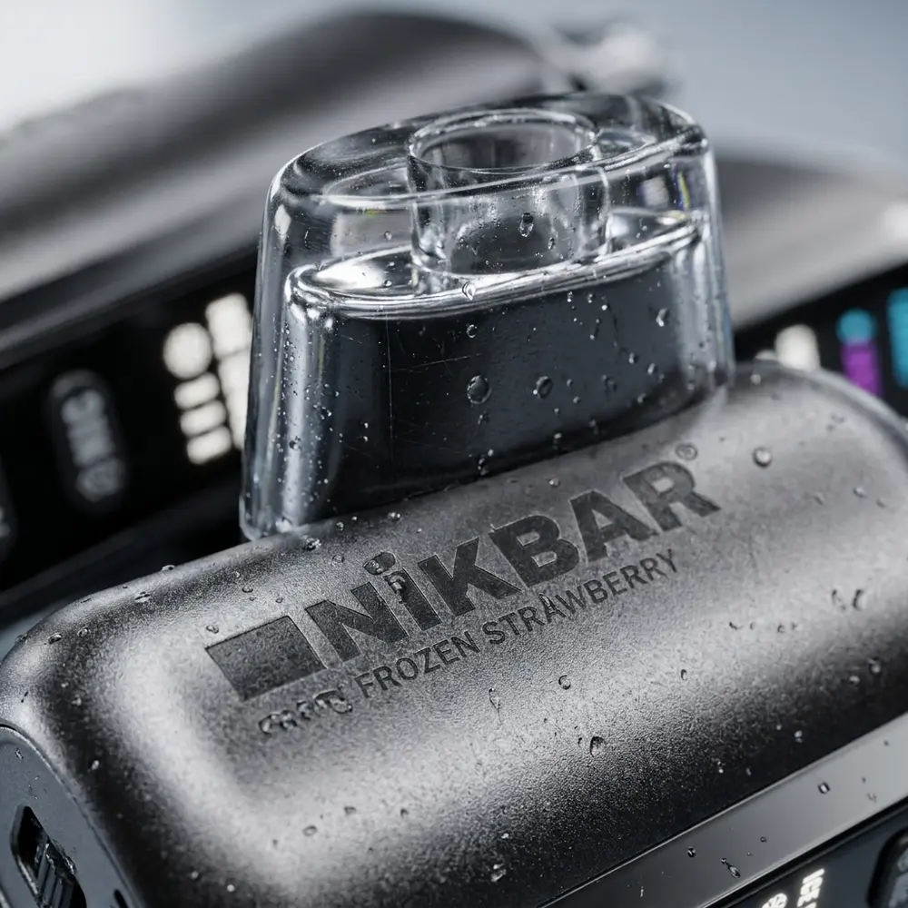 Detalhe macro do logo e textura do NikBar Ice Baby 40.000 puffs com condensacao e reflexos metalicos - Vapor Gringo