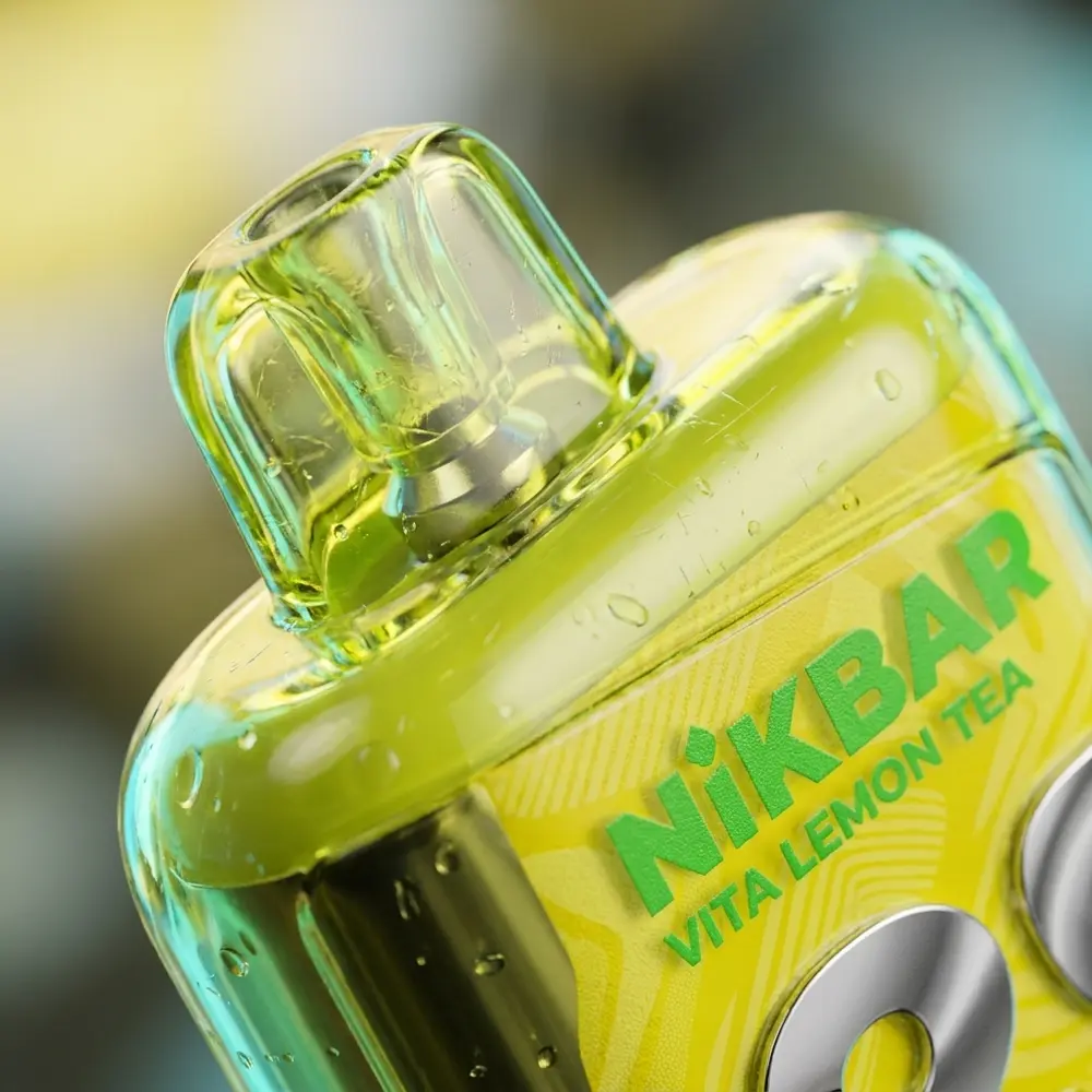 Close-up do NikBar Vita Lemon Tea na boca e rótulo, com gotas de condensação e reflexos de cor - Vapor Gringo