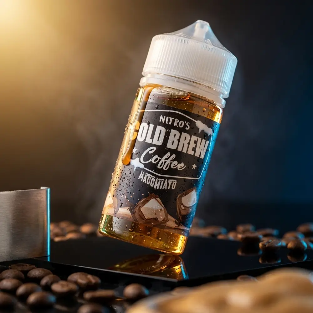 Garrafa Liquido Nitro's Cold Brew Macchiato sobre base acrilica escura, gotas de condensacao e grãos de café - Vapor Gringo