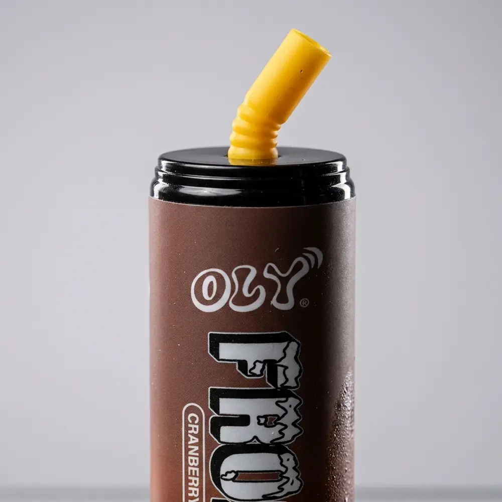 Detalhe do Oly Frozen 7.000 puffs mostrando logo, boca e textura metálica com fundo suave desfocado - Vapor Gringo