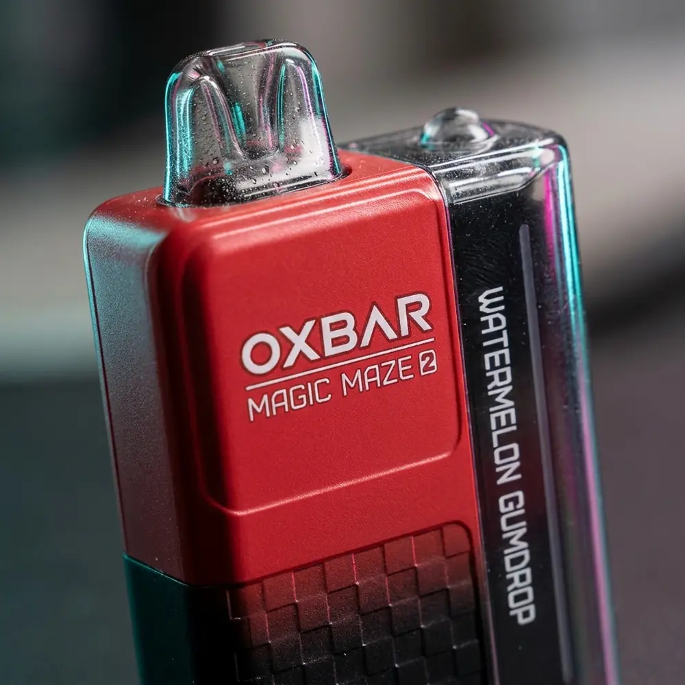 Detalhe do bocal e rótulo do Pod Descartável Oxbar Magic Maze 2.0 Watermelon Gumdrop, textura, gotas e micro-reflexos visíveis - Vapor Gringo