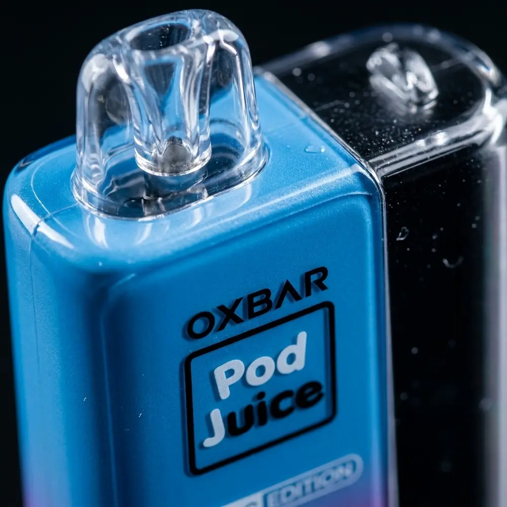 Close-up do Pod Descartavel Oxbar Pod Juice, detalhe do bocal e do logo com gotas e reflexos metalicos - Vapor Gringo