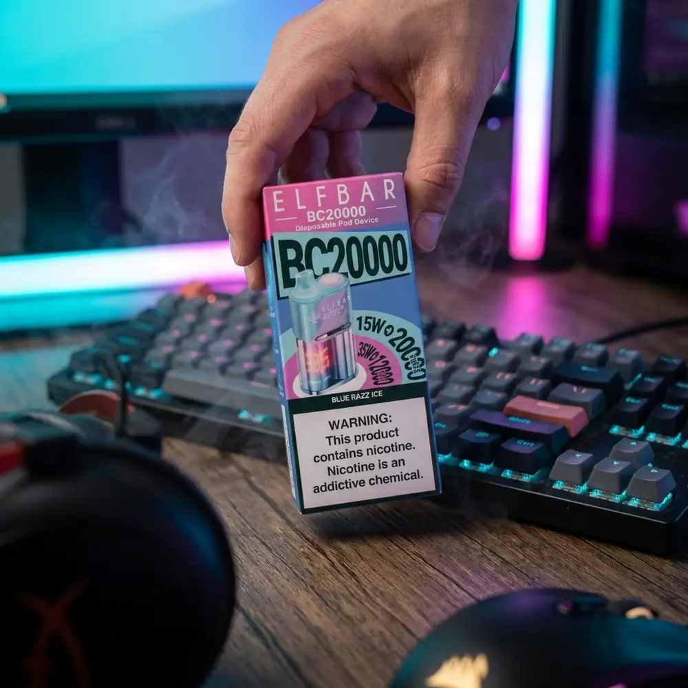Pessoa segurando Pod descartável Elf Bar BC20000 Blue Razz Ice em mesa gamer com iluminação RGB - Vapor Gringo