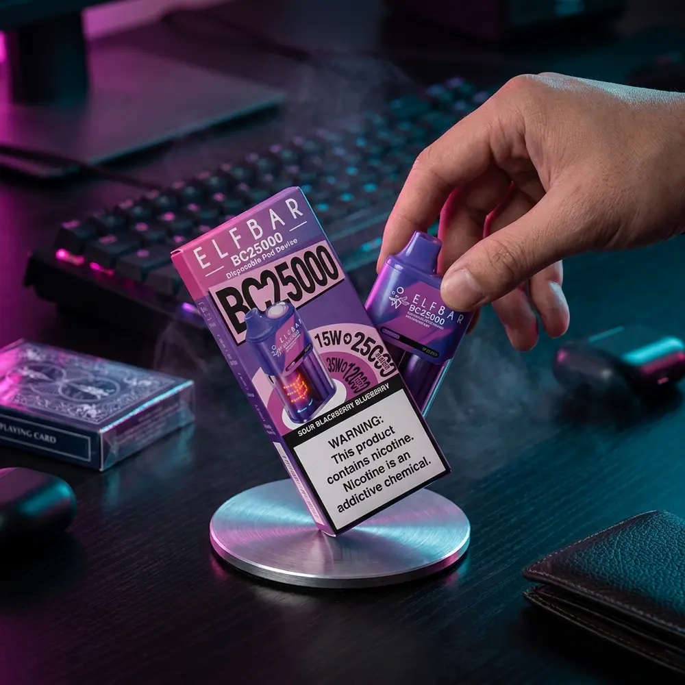 Pod descartavel Elf Bar BC25000 apoiado em mesa gamer RGB, teclado colorido e mao alcançando o dispositivo - Vapor Gringo