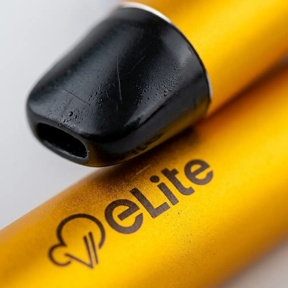 Close-up do Pod Descartavel Elite Iced Mango Lemonade mostrando bocal, logo legivel e gotas de condensacao na superficie - Vapor Gringo