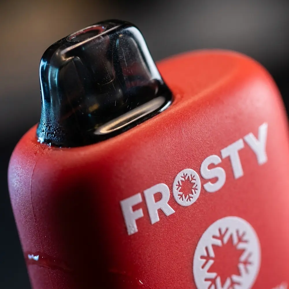 Detalhe macro do Pod Descartavel Frosty mostrando logo, textura, gotas de condensacao e reflexos metalizados - Vapor Gringo