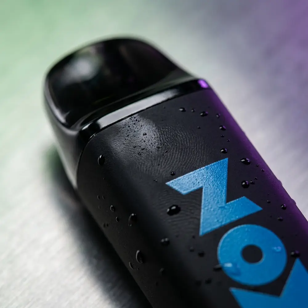 Macro do Pod descartável Zomo Party Apple Grape mostrando tip, textura do corpo, logo e gotas de condensação - Vapor Gringo