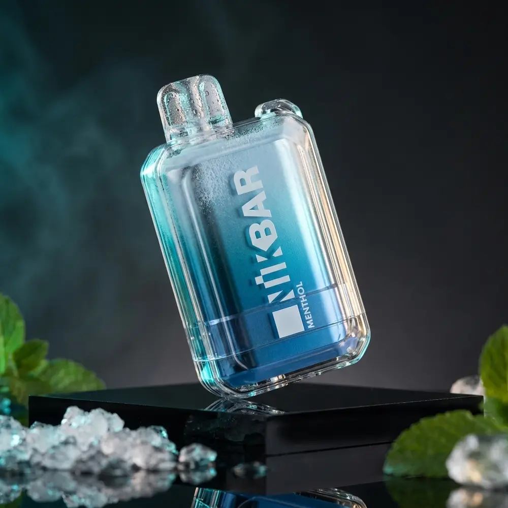 Pod Descartavel NikBar Menthol sobre acrilico preto com reflexos frios e gotas de condensacao - Vapor Gringo