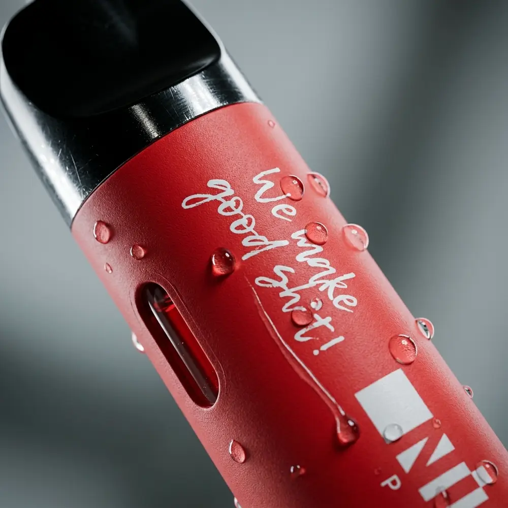 Close-up do mouthpiece do Pod NikBar Plus Strawberry Ice com gotas de condensacao e detalhe nítido do logo - Vapor Gringo