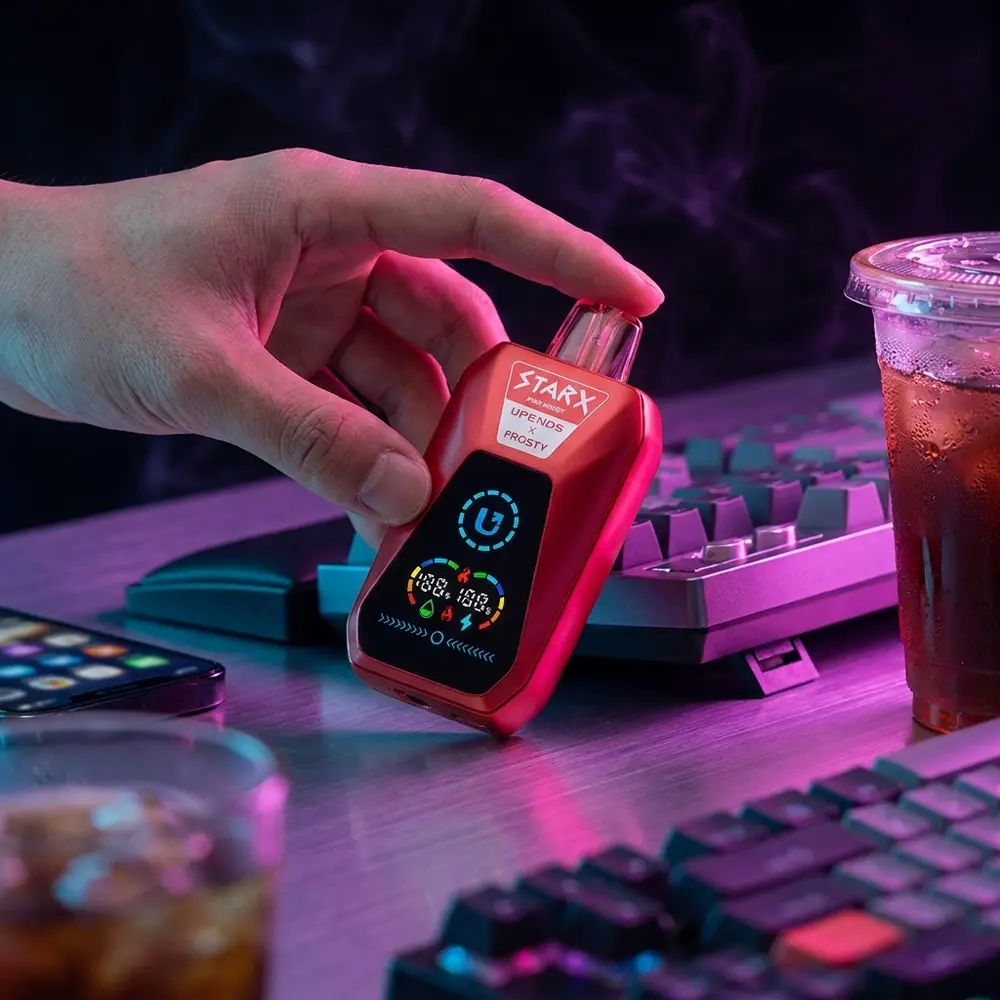 Pod StarX Frosty Pink Burst em bancada gamer RGB, proximo a teclado mecanico e copo com condensacao - Vapor Gringo