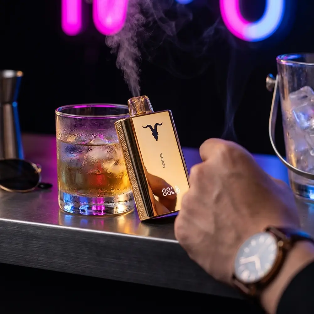 Pod Descartável V120 Pró Ignite Gold apoiado em balcão de bar com copo condensado e luzes neon ao fundo - Vapor Gringo