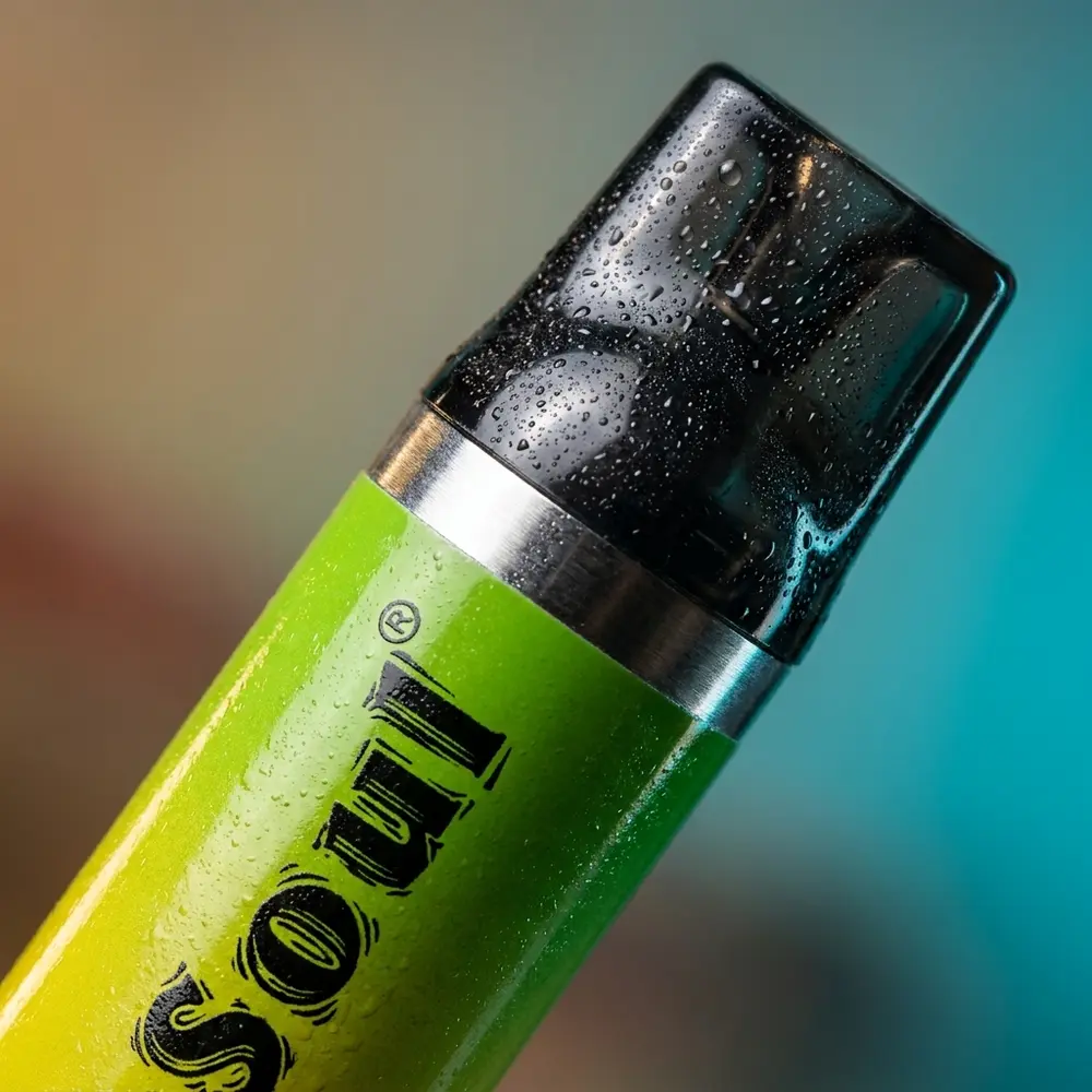 Detalhe macro do pod Vapesoul Apple Ice mostrando logo, bocal, condensacao e reflexos metalicos - Vapor Gringo