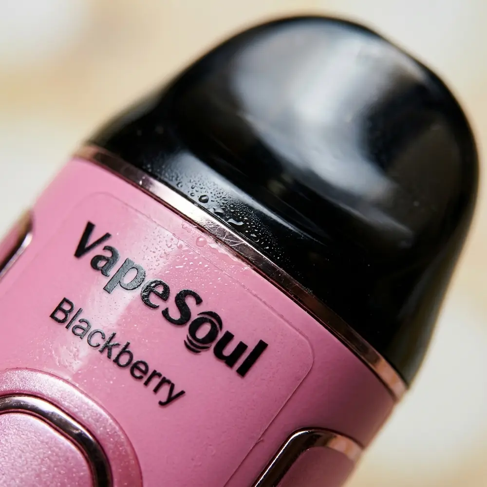 Close-up macro do pod Vapesoul Blackberry mostrando logo, mouthpiece, gotas de condensacao e textura do rótulo - Vapor Gringo