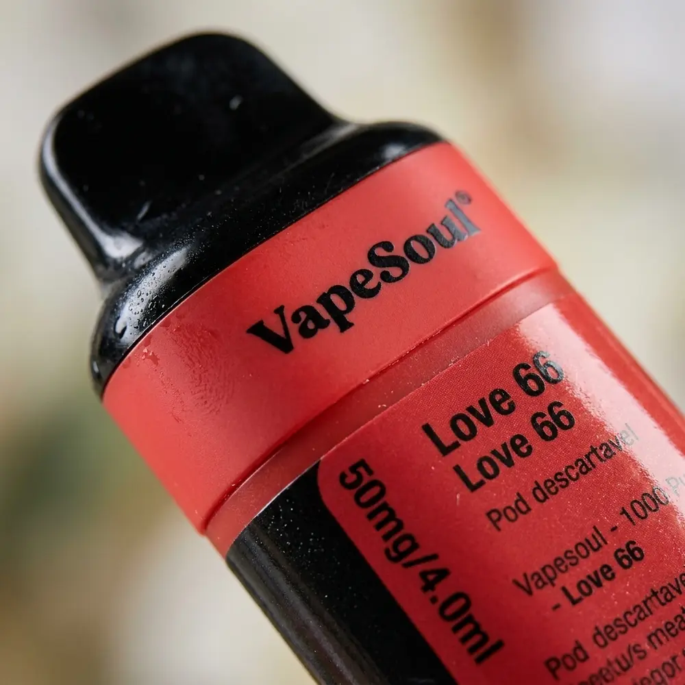 Detalhe macro do pod Vapesoul Love 66, foco no bocal, rotulo, janela de juice e gotas de condensacao - Vapor Gringo
