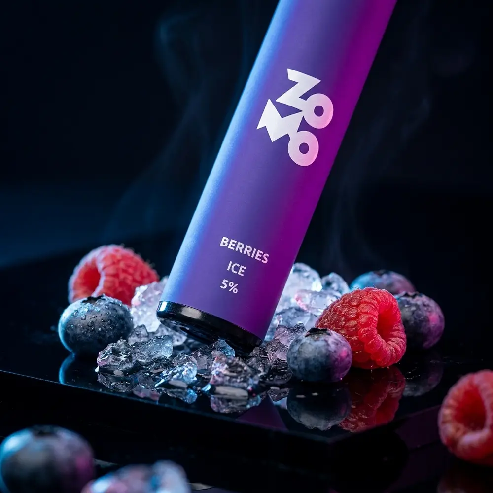 Pod Descartavel Zomo Flow Berries Ice sobre base acrilica preta com gelo e frutas vermelhas em close cinematografico - Vapor Gringo