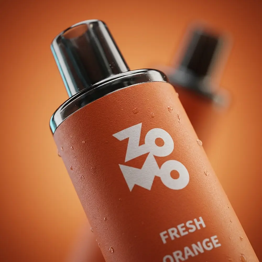 Close macro do bocal e rótulo do Pod Zomo Flow Fresh Orange com gotas de condensacao e textura detalhada - Vapor Gringo