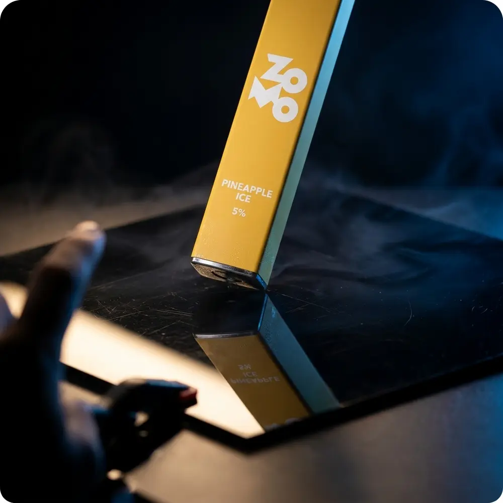 Pod Descartável Zomo Go! Pineapple Ice em close de estúdio sobre acrílico brilhante com reflexos - Vapor Gringo