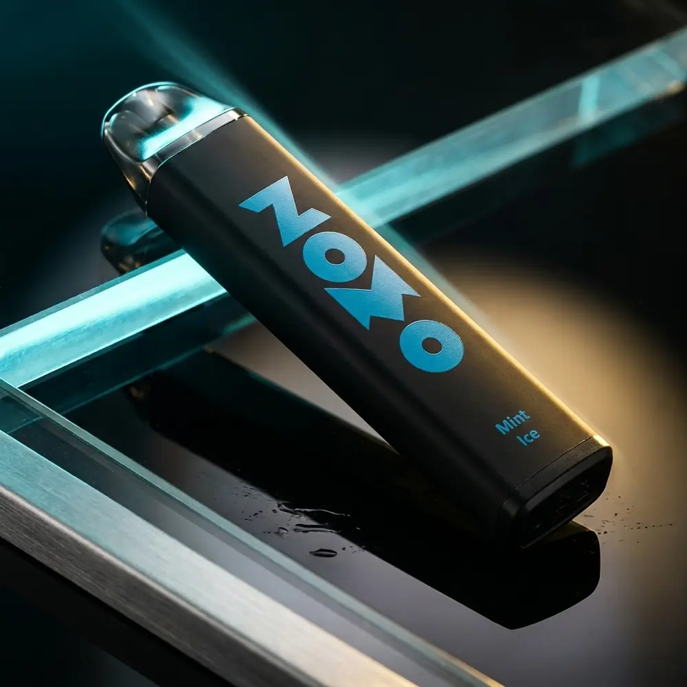 Pod descartavel Zomo Mesh Coil Mint Ice 800 puffs sobre base acrilica preta com reflexos mint e luz dramática - Vapor Gringo