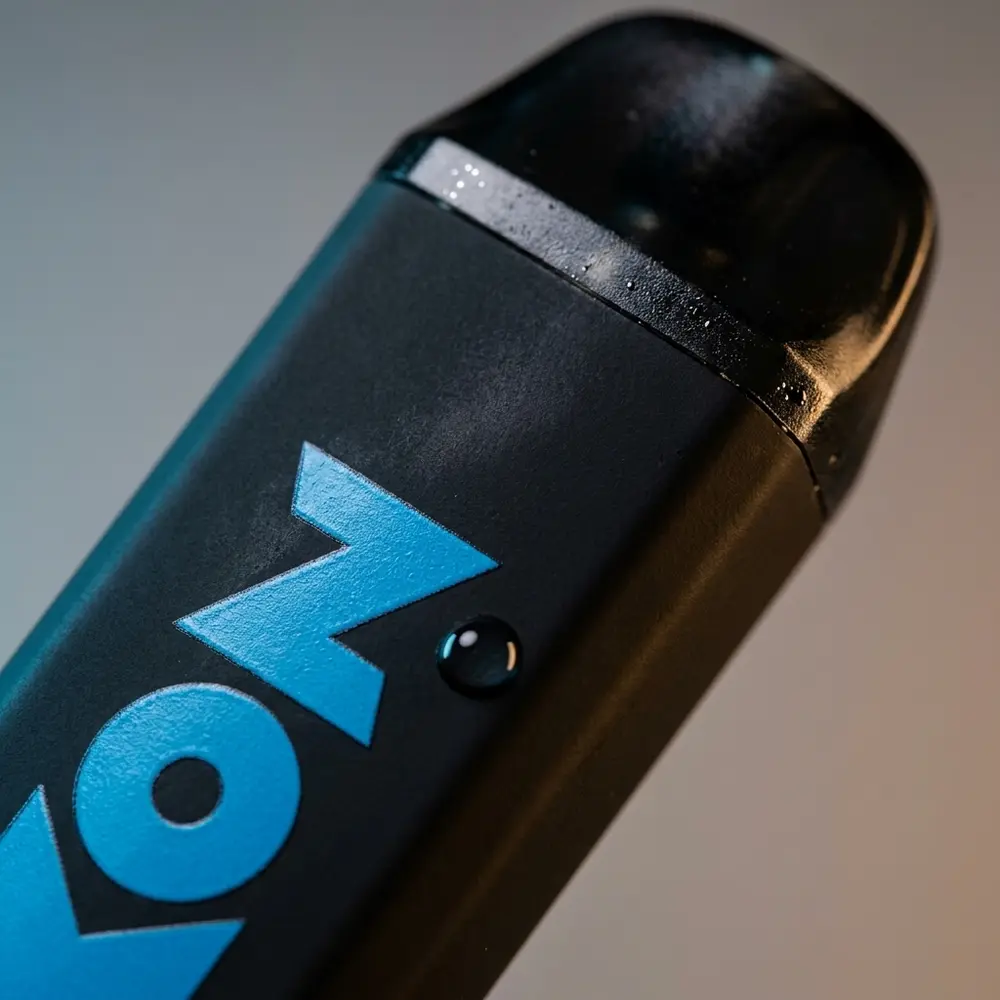 Detalhe do bocal e logo do Pod Zomo Mesh Coil Mint Ice 800 puffs com texturas, reflexos e microdetalhes visíveis - Vapor Gringo
