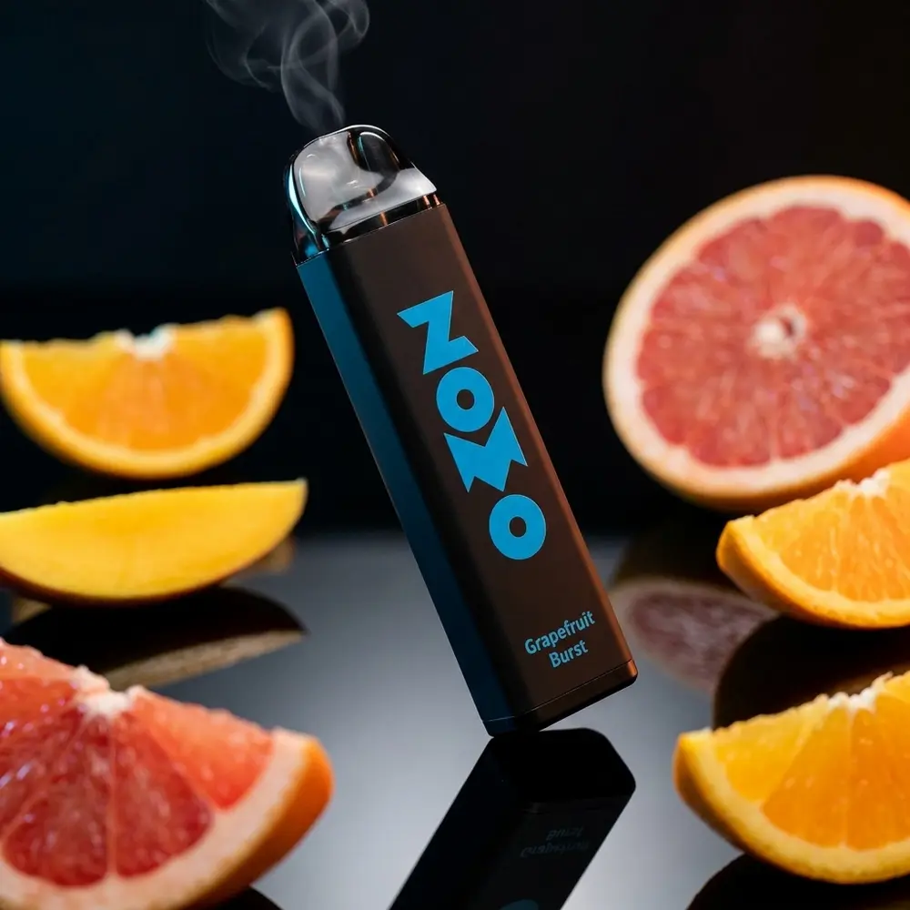 Pod descartável Zomo Party Grapefruit Brust sobre acrílico preto com fatias de toranja e iluminação dramática - Vapor Gringo