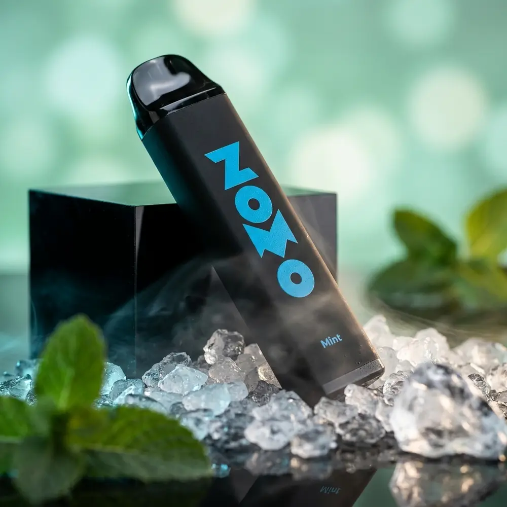 Pod descartavel Zomo Party Mint 800 puffs sobre base acrilica com gelo e nevoa fria, close promocional - Vapor Gringo