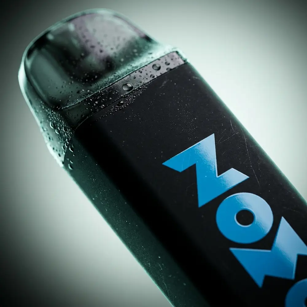 Close do bocal e logo do Pod Zomo Party Mint 800 puffs com gotas de condensacao e reflexos metalicos - Vapor Gringo
