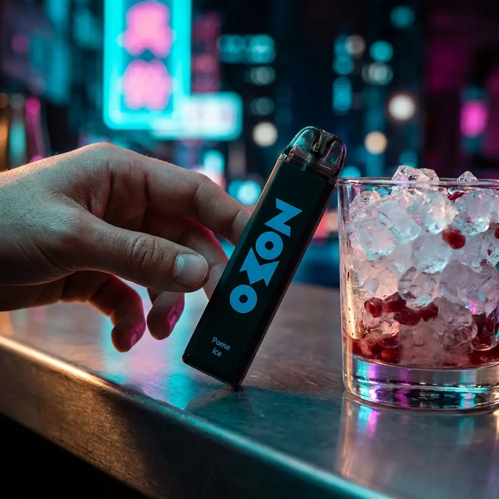 Pod Zomo Party Pome Ice numa bancada urbana neon com copo de romã e gelo e uma mão parcialmente em cena - Vapor Gringo