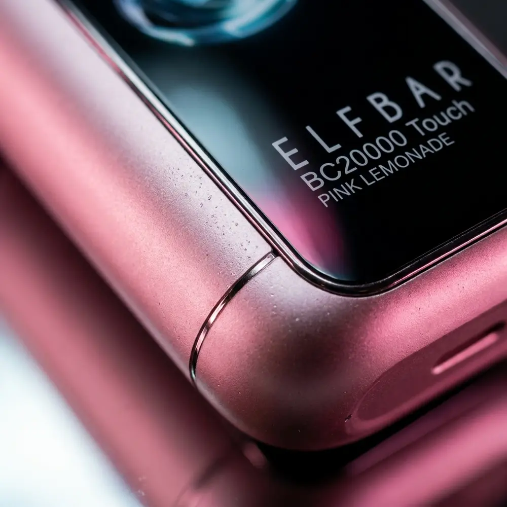 Close macro do Pod Descartável Elf Bar BC20000 Pink Lemonade mostrando textura, logo, reflexos e gotas de condensação - Vapor Gringo