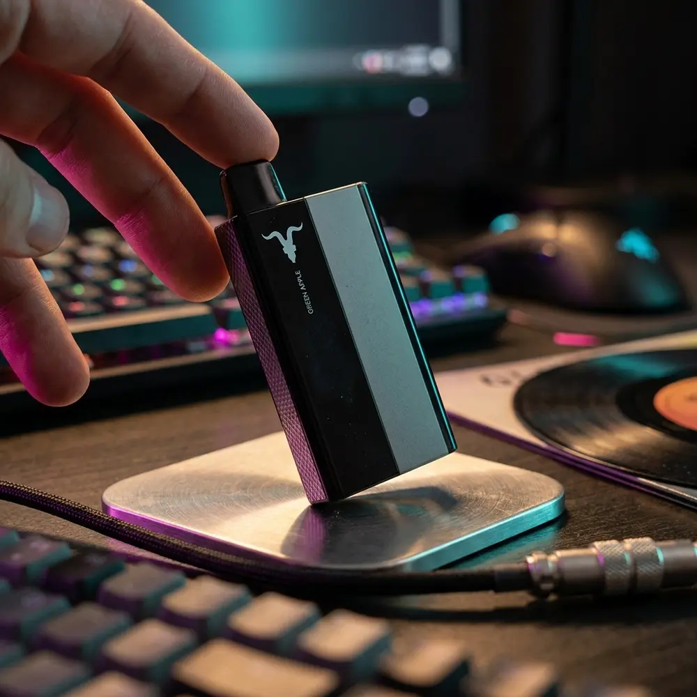 Pod Descartável Ignite P100 Pró sobre mesa gamer RGB, teclado mecânico ao fundo e reflexos neon na superfície - Vapor Gringo
