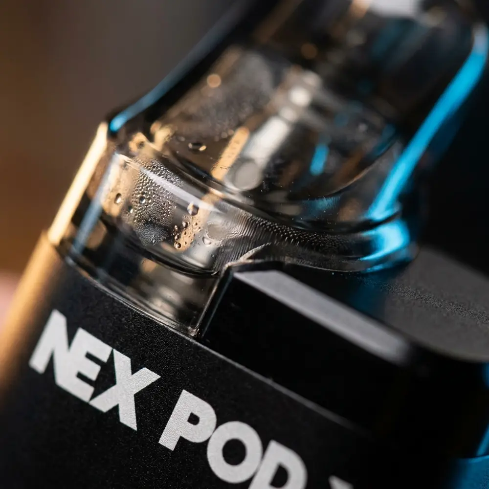 Macro do NexPod 3500 mostrando boquilha, janela do pod transparente, malha 1,1Ω e gotas de condensacao - Vapor Gringo