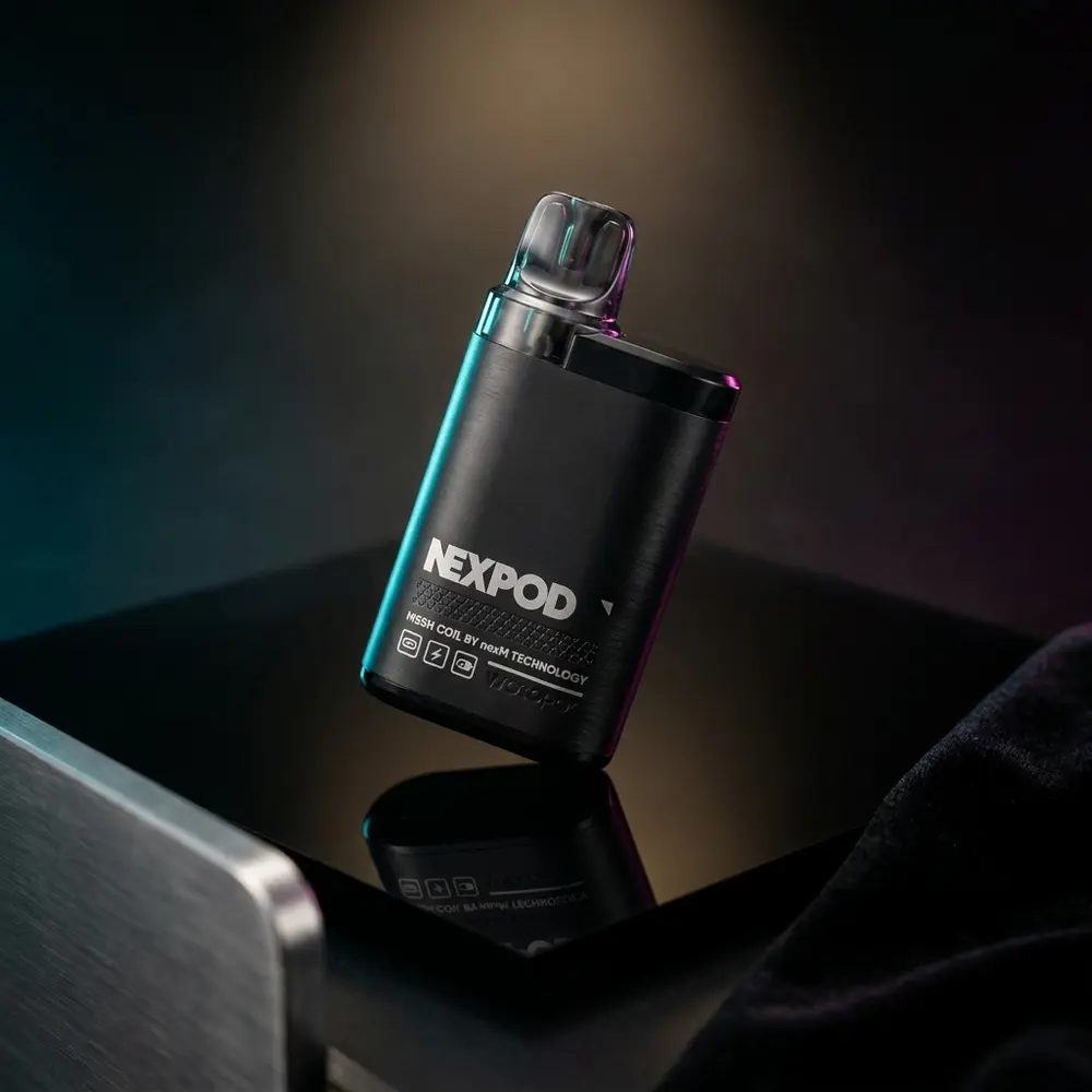 Pod Recarregável NexPod Tropical Ice preto sobre superfície acrílica brilhante com reflexos neon azuis e magenta - Vapor Gringo