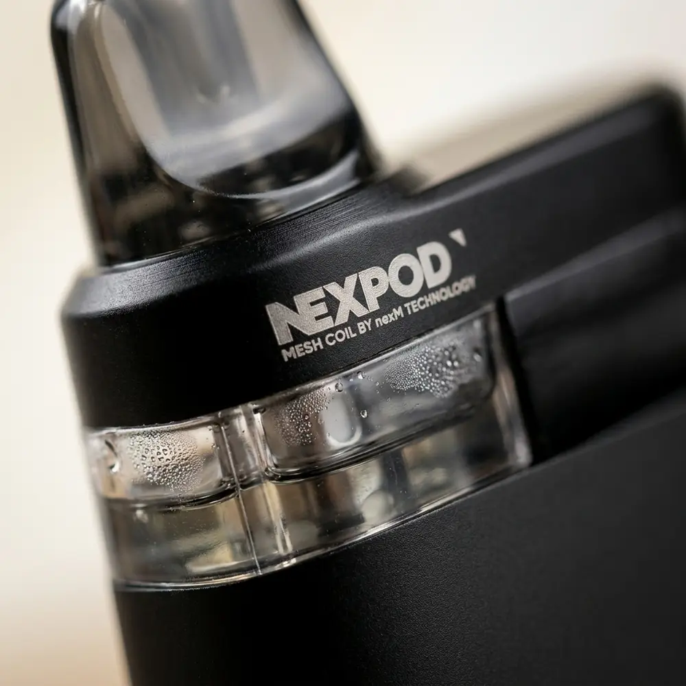 Detalhe do NexPod Tropical Ice com logo visível, acabamento anodizado, janela do pod com condensação e texturas metálicas - Vapor Gringo